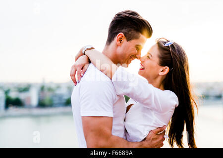 Young romantic couple hugging and about to kiss in beautiful sunset