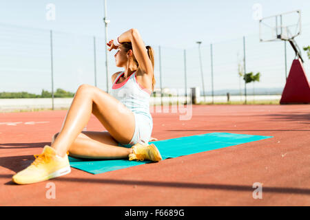 Exhausted young beautiful woman taking a rest on a hot summer day Stock Photo
