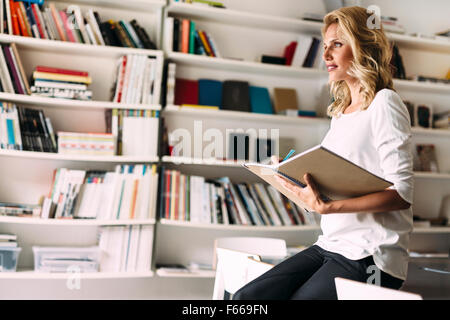 Stunning blonde woman reading Stock Photo