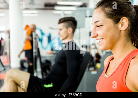 A handsome man and a beautiful woman working out together in a gym and bonding Stock Photo