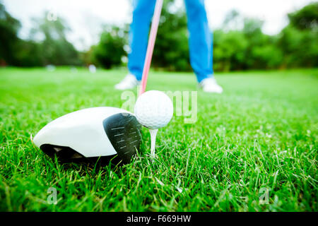 Golfer getting ready to take a shot. Wide angle photo and closeup Stock Photo