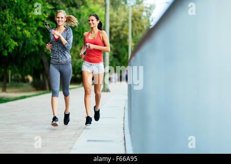 Two women exercising by jogging in city Stock Photo