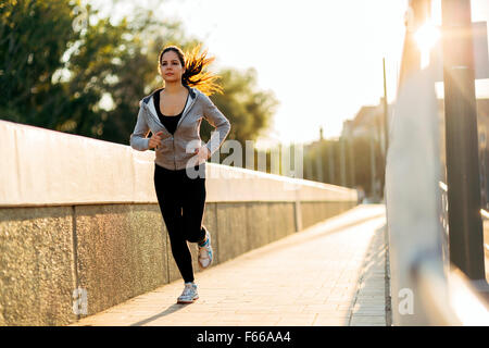 Beautiful female jogging in city and keeping her body in shape Stock Photo