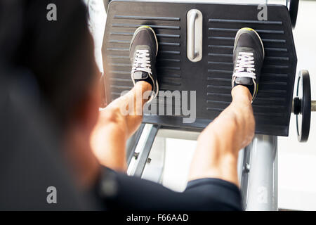 Young male working out in a gym and doing leg exercises Stock Photo