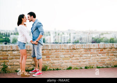 Young and beautiful couple in love being close to each other outdoors and about to kiss Stock Photo