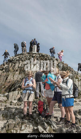 A group of female walkers texting on the summit of Snowdon, Snowdonia National Park, North Wales, UK Stock Photo