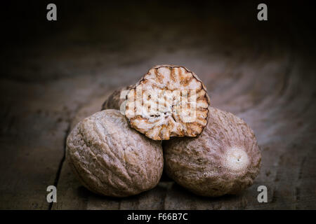 Nutmeg on an old wooden table closely. Stock Photo