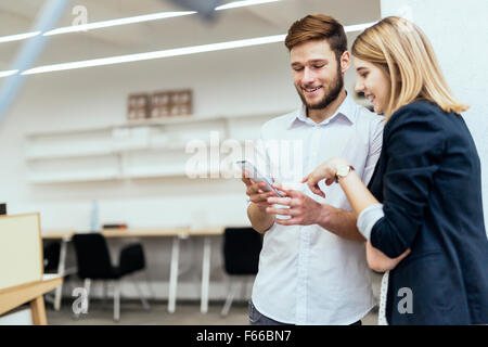 Colleagues laughing together in office during work Stock Photo