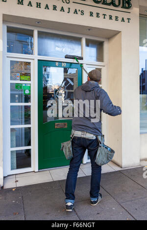 Window cleaner cleaning windows of a business, Nottingham, England, UK Stock Photo