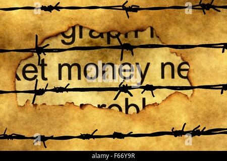 Money paper hole against barbwire Stock Photo