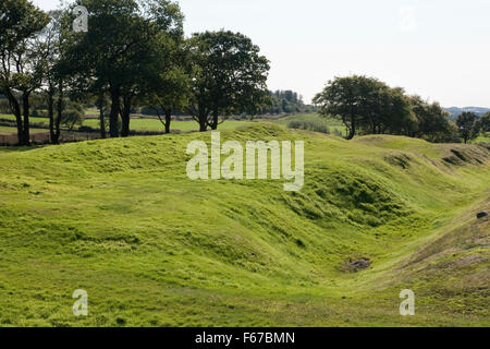 Looking SW from outer bank of the Antonine Wall W of Rough Castle Roman fort, Falkirk: deep ditch (vallum), wide berm, remains of rampart (L). Stock Photo