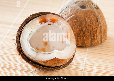 Moulded half coconut closeup, opened seed interior, mature moldy and rotten nut bad food wastage, halved coconut shells garbage Stock Photo