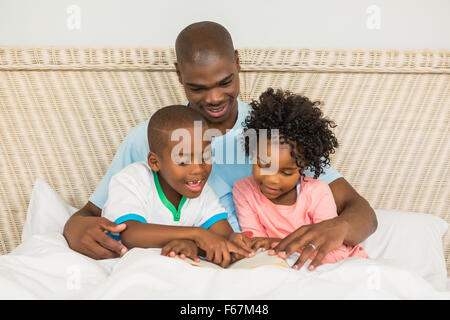 Father reading a book with his children Stock Photo