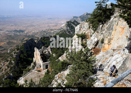 A senior female tourist climbs a rocky precipice to reach Buffavento Castle in the Turkish Republic of North Cyprus KATHY DEWITT Stock Photo