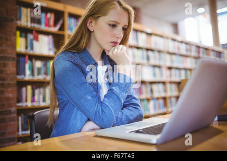 Focused student using laptop in library Stock Photo