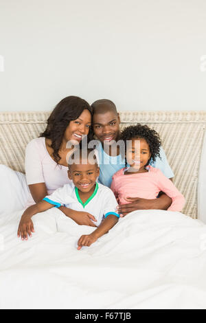 Happy family lying on bed Stock Photo
