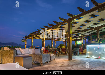 People enjoy the view from one of the beach bars along the coast from Lindos on the Greek island of Rhodes. Stock Photo