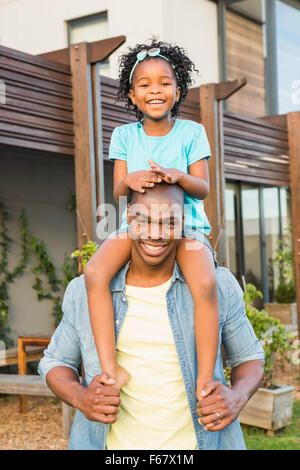 Smiling father giving daughter a piggyback Stock Photo