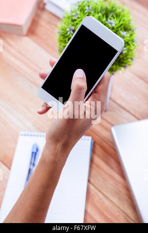 Overhead of feminine hand using smartphone Stock Photo