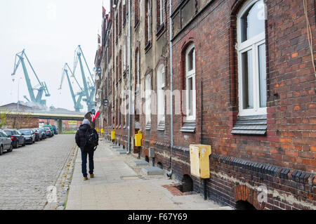 Shipyard neighborhood tenements and cranes. Gdansk, Poland Stock Photo