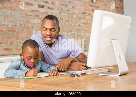 Cute son doing his homework with father Stock Photo
