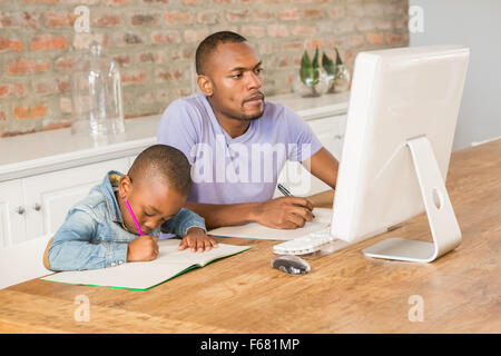 Cute son doing his homework with father Stock Photo