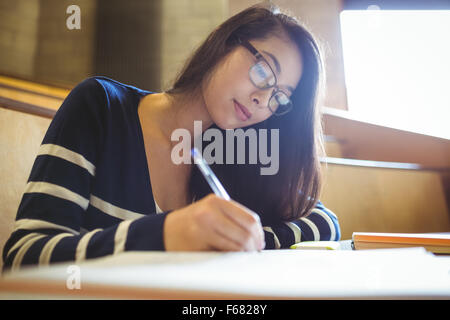 Focused student writing on notebook Stock Photo