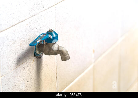 old faucet on concrete wall, save the water concept Stock Photo
