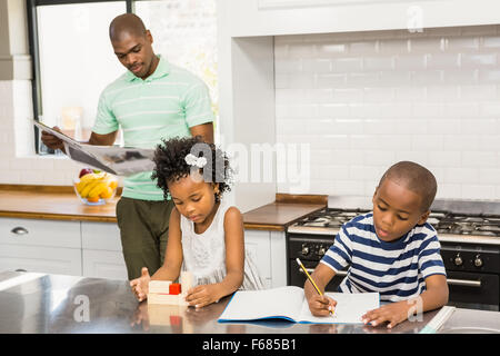 Children playing and drawing in the kitchen Stock Photo