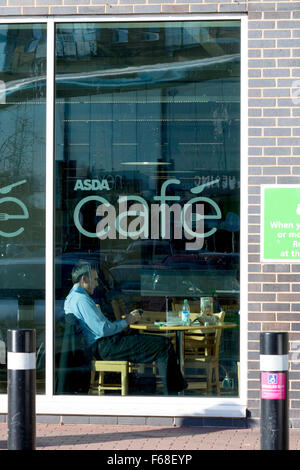 Man sitting in Asda's café, Feltham, Middlesex Stock Photo