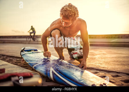 Man waxing surfboard to surf. Stock Photo
