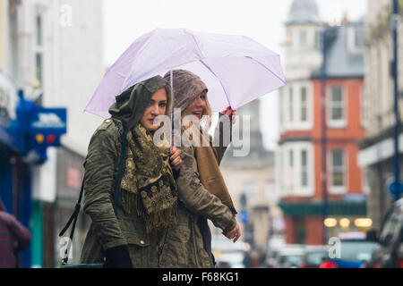 Aberystwyth Wales UK, Saturday 14 November 2015  Two young women struggle avoid getting soaked on the streets of Aberystwyth as a band of torrential rain sweeps in from the west in the wake of Storm Abigail  Amber and red warnings are in place for the risk of severe flooding in north wales and the north or England, with up to  8” (20cm) of rain forecast to fall on already saturated ground in some areas in the next 24 hours    photo Credit:  Keith Morris /Alamy Live News Stock Photo