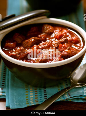 Bowl of red chili in a brown bowl with a spoon. Stock Photo