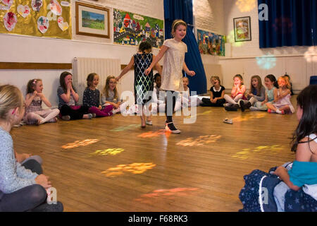 Horizontal portrait of young girls sitting in a circle during a dance competition at a birthday party. Stock Photo