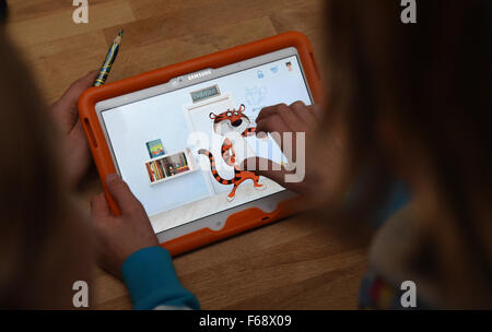 Oldenburg, Germany. 10th Nov, 2015. Ten-year-old Peeke plays an educational game on a tablet with his mother at their home in Oldenburg, Germany, 10 November 2015. Publishing companies are increasingly offering apps and educational games in addition to traditional storybooks. Photo: CARMEN JASPERSEN/dpa/Alamy Live News Stock Photo