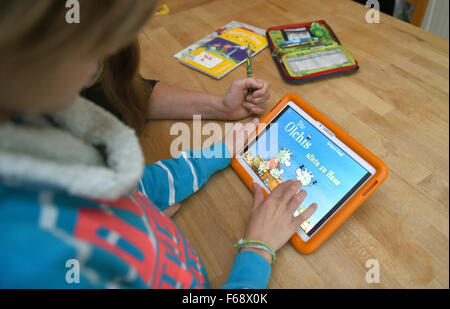 Oldenburg, Germany. 10th Nov, 2015. Ten-year-old Peeke plays the educational game 'Die Olchis' (The Olchis) on a tablet with his mother at their home in Oldenburg, Germany, 10 November 2015. Publishing companies are increasingly offering apps and educational games in addition to traditional storybooks. Photo: CARMEN JASPERSEN/dpa/Alamy Live News Stock Photo