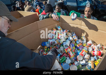 St. Clair Shores, Michigan USA. Volunteers pack food donated for needy families in the Detroit area in an annual program called Scouting for Food. Boy Scouts and Girl Scouts collected bags of non-perishable food which was sorted into boxes for distribution through the Gleaners Food Bank. Stock Photo