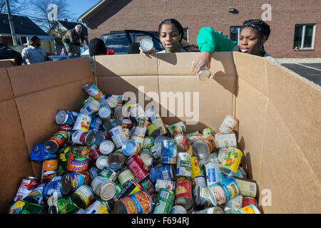 St. Clair Shores, Michigan USA. Volunteers pack food donated for needy families in the Detroit area in an annual program called Scouting for Food. Boy Scouts and Girl Scouts collected bags of non-perishable food which was sorted into boxes for distribution through the Gleaners Food Bank. Stock Photo