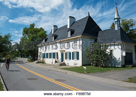 Road Cyclist Biking Past Historic Manoir Mauvide-Genest, Saint-Jean-de- I'ile-d'Orleans, Quebec, Canada