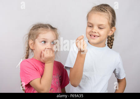 Six year old girl showing her the other girl had fallen Milk front upper teeth Stock Photo