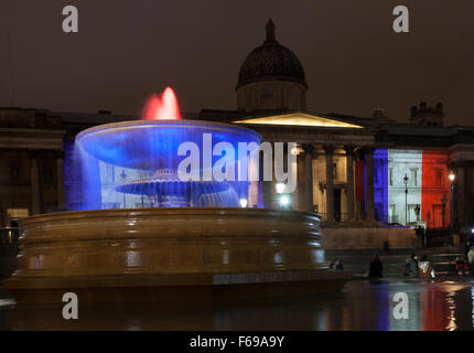 14 November 2015 Fountain in front of National Portrait Gallery. Trafalgar Square London UK. Buildings around London are illuminated with the colours of the French lag The Tricolor in a show of support in light of the terrorist attacks in Paris. Stock Photo