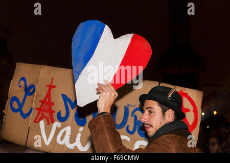 London, Uk. 14th November 2015. A man holds a heart shaped sign in the colours of the French flag as thousands gather in Trafalgar Square to pay their respect to victims in France and show their solidarity in the wake of the Paris attacks Stock Photo