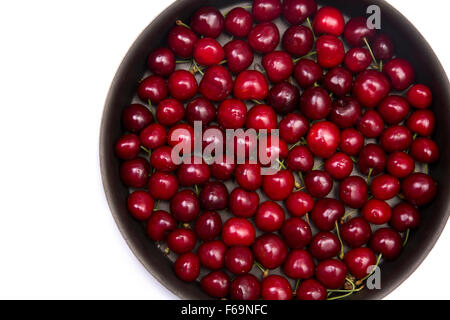 Red cherries in round baking tin, isolated on white background with copy-space for your text Stock Photo