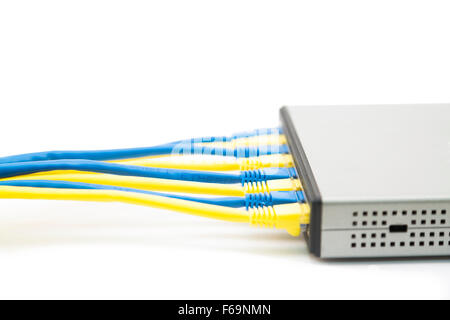 blue and yellow computer network cables plugged into a switch Stock Photo