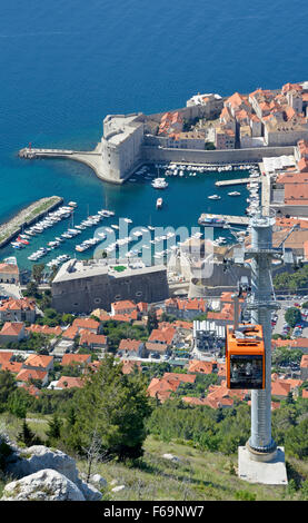 Dubrovnik Cable Car loaded with passengers near the top of Srd Hill with views looking down to the old walled town and small boats in harbour Stock Photo