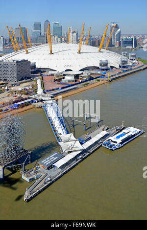 Thames Clipper River Bus service aerial view at North Greenwich Pier with O2 dome & Canary Wharf skyline beyond Stock Photo