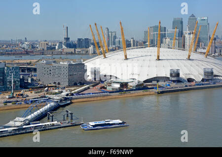 O2 arena white roof aerial view River Thames loops behind  Greenwich Peninsula Thames Clipper departs towards Canary Wharf skyline London England UK Stock Photo