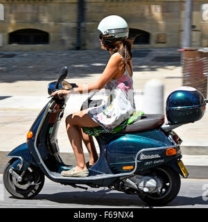 Young woman riding a Vespa motor scooter on a very hot July summers day in Aix en Provence France Stock Photo