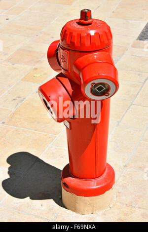 Close up of Fire hydrant painted bright red standing on French pavement in Aix en Provence South of France Stock Photo