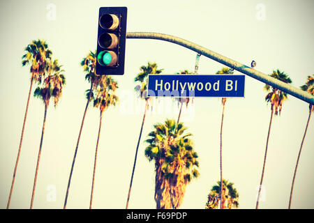Cross processed Hollywood boulevard sign and traffic lights with palm trees in the background, Los Angeles, USA.